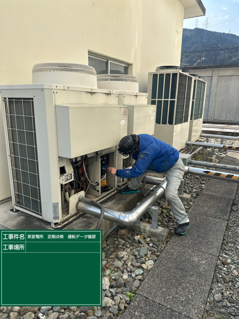 西条市の変電所にて業務用エアコン室外機の定期点検を行い、運転データの測定と内部確認を実施している様子
