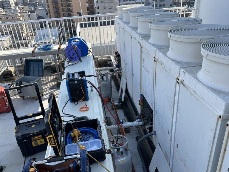 松山市で解体前の業務用エアコンからフロンガスを回収。冷媒回収装置を使用し、法令に基づいて安全にフロンガスを回収している様子。